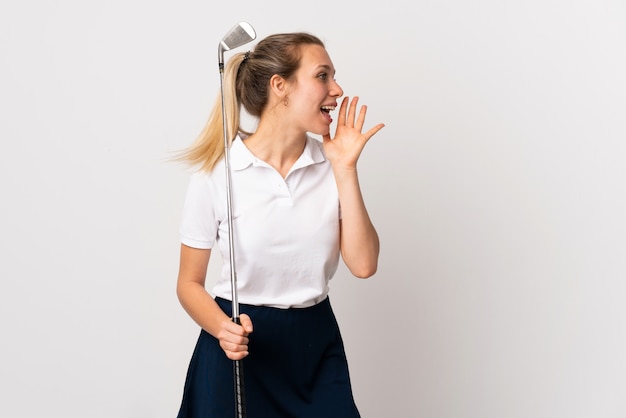 Young golfer woman over isolated white wall shouting with mouth wide open