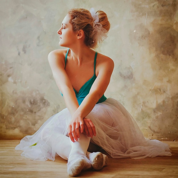 Young and graceful ballerina in pointe shoes and a tutu dances in the studio. Choreography, dancing