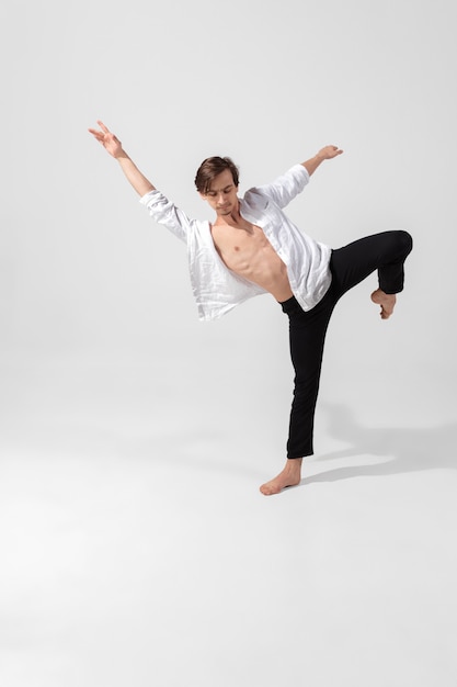 Young and graceful ballet dancer in minimal black style isolated on white studio background