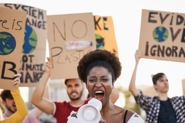 Photo young group of demonstrators on road from different culture and race fighting for climate change - focus on african woman face