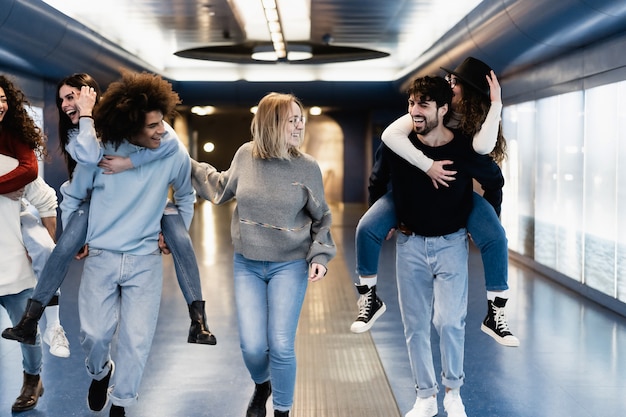 Young group of people having fun in subway metro station - Main focus on center woman face