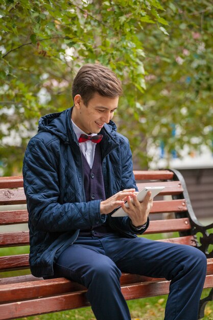 Young guy on a bench with a gadget