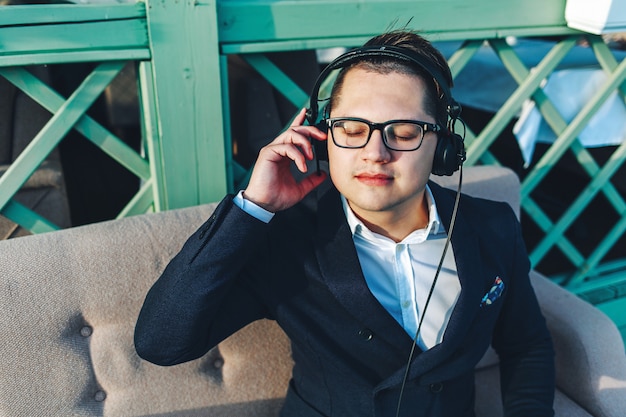 Young guy in headphones enjoys music.