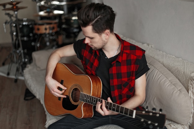 Young guy practicing guitar