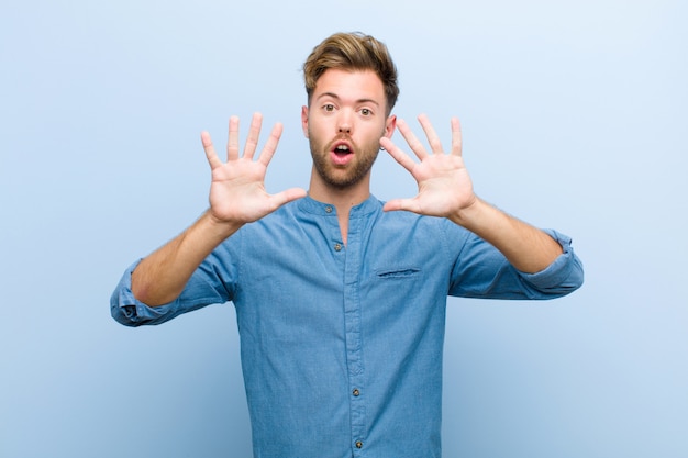 young guy showing number ten or tenth with hand forward