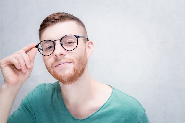 Young guy with glasses is smiling. Closeup portrait.