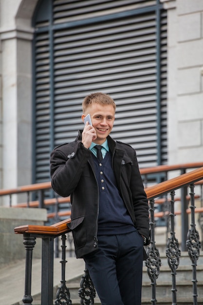 Young guy with a phone on a historic building