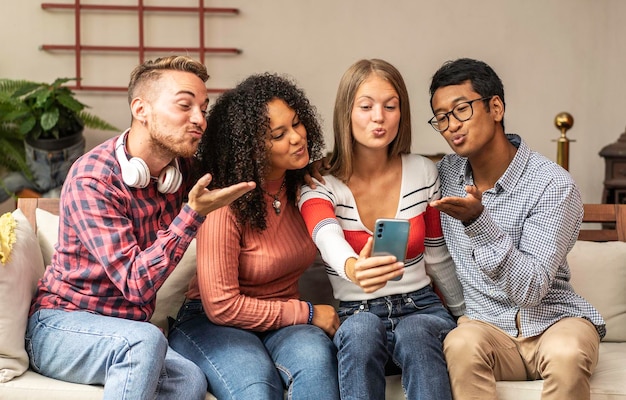 Young guys group sending kisses during a video call with friends Community concept with multicultural and multiethnic friends having fun video calling on web social platform Diversity friendship