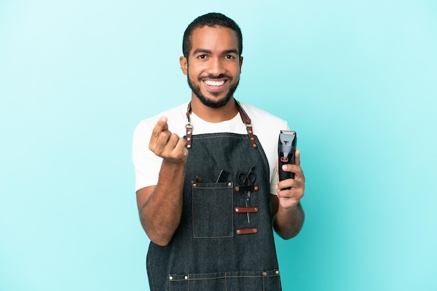 Young hairdresser latin man isolated on blue background making money gesture