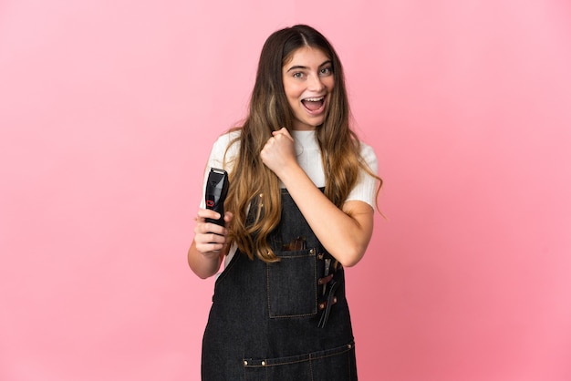 Young hairdresser woman isolated celebrating a victory