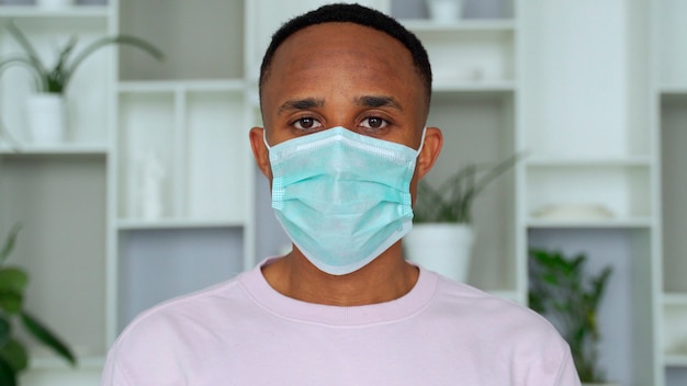 Young handsome african man wore face mask preventing prevented himself from the outbreak in his society