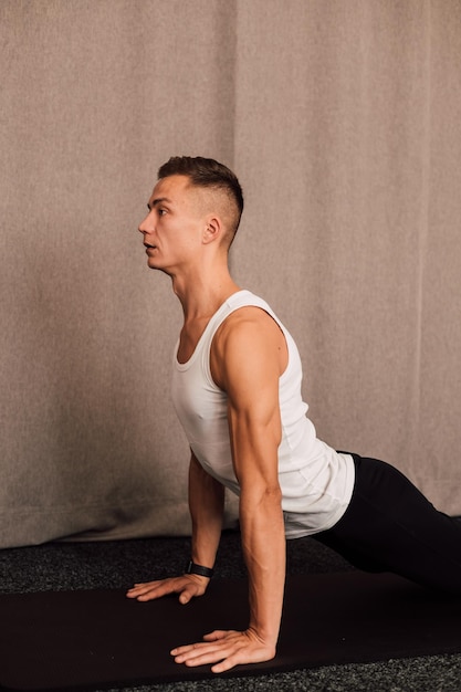 Young handsome athlete pushups from the floor at home