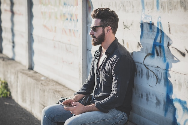 young handsome attractive bearded model man using smartphone