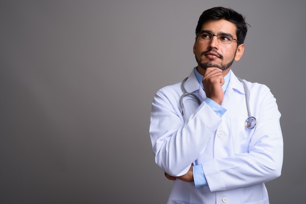 young handsome bearded Persian man doctor wearing eyeglasses 