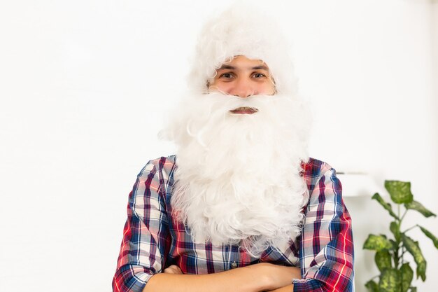 young handsome bearded santa claus man with long beard and new year hat, christmas background