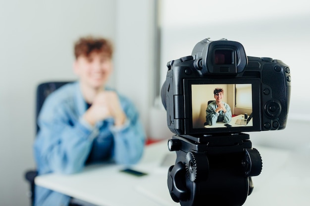 Young handsome blogger with camera Man filming himself with a modern camera Blog concept