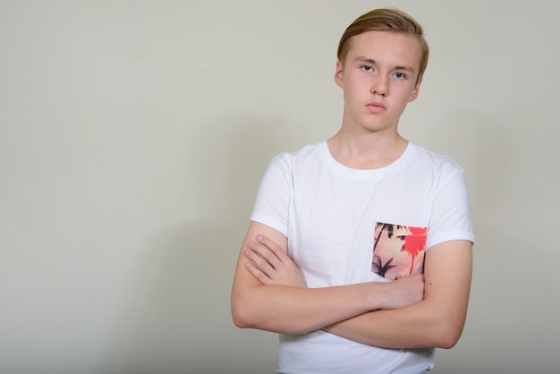 young handsome blond teenage boy against white space