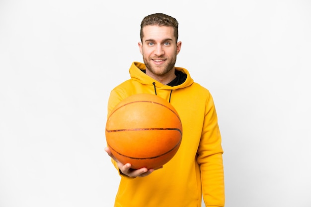 Young handsome blonde man over isolated white background playing basketball