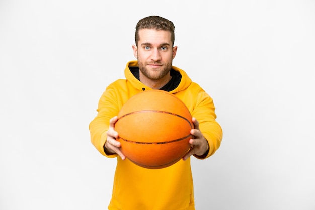 Young handsome blonde man over isolated white background playing basketball