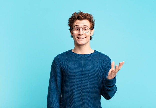 Photo young handsome boy feeling happy, surprised and cheerful, smiling with positive attitude, realizing a solution or idea