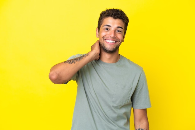 Young handsome Brazilian man isolated on yellow background laughing