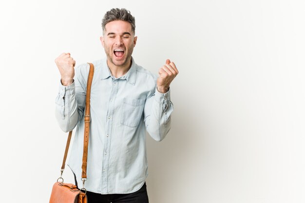 Young handsome business man cheering carefree and excited. Victory concept.