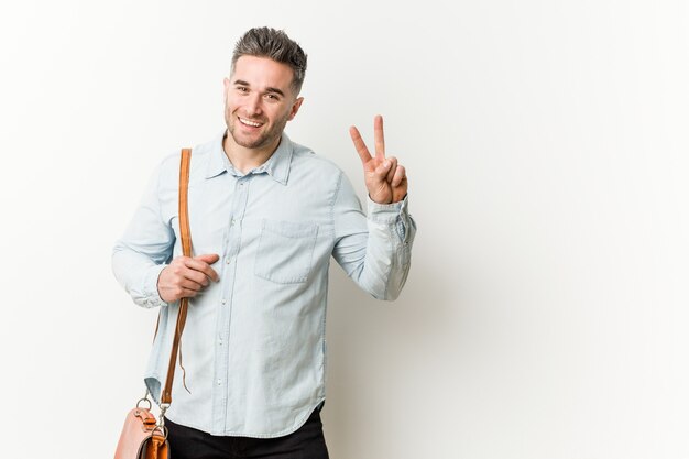 Young handsome business man showing victory sign and smiling broadly.