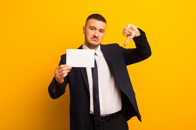 Young handsome businessman  against flat background with a placard