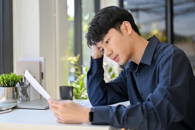 Young handsome businessman concentrate on his document while working on the office room