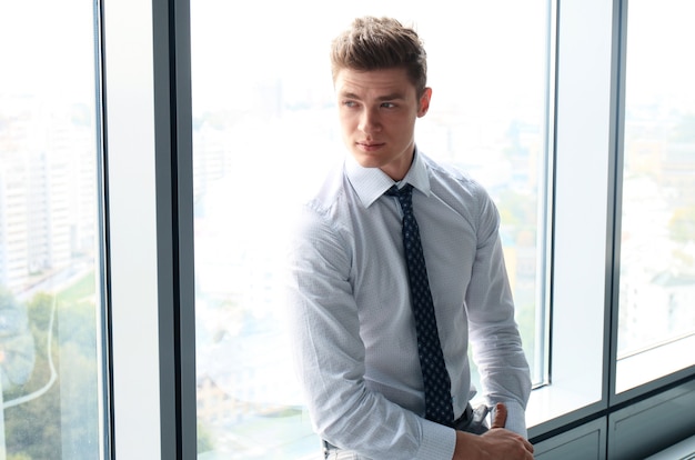 Young handsome businessman smiling in an office environment