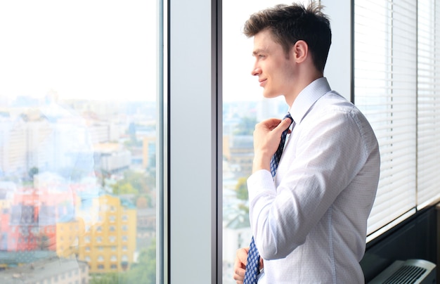 Young handsome businessman smiling in an office environment