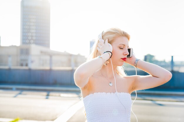 Photo young handsome caucasian long blonde straight hair woman dancing in the streets of the city