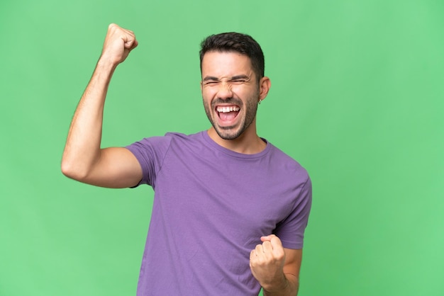 Young handsome caucasian man over isolated background celebrating a victory