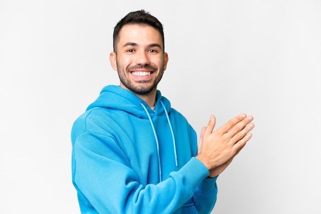 Young handsome caucasian man over isolated white background applauding