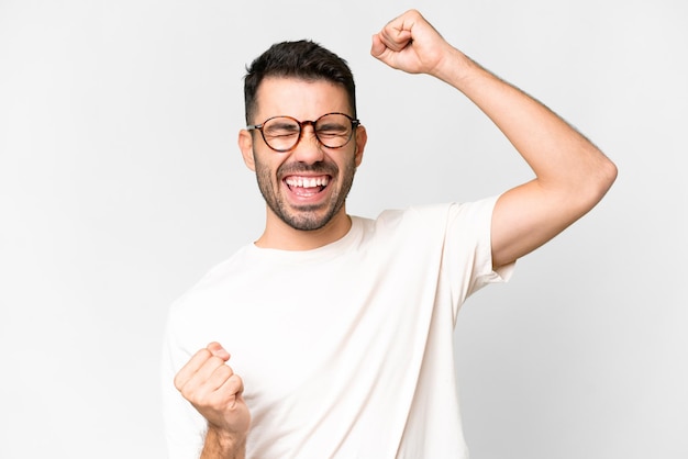 Young handsome caucasian man over isolated white background celebrating a victory