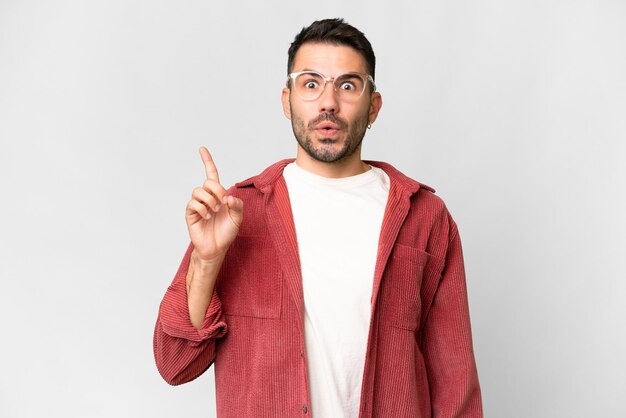 Young handsome caucasian man over isolated white background intending to realizes the solution while lifting a finger up