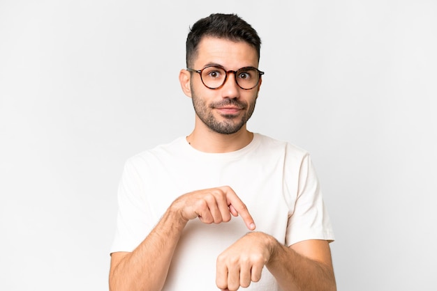 Young handsome caucasian man over isolated white background making the gesture of being late