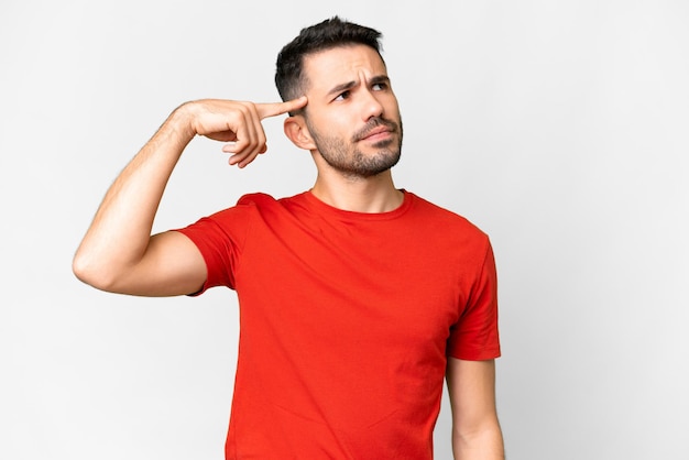 Young handsome caucasian man over isolated white background making the gesture of madness putting finger on the head