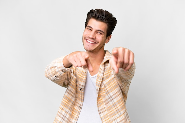 Young handsome caucasian man over isolated white background pointing front with happy expression