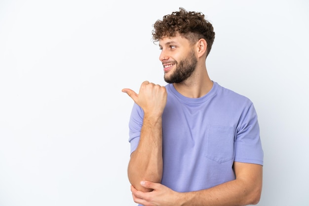 Young handsome caucasian man isolated on white background pointing to the side to present a product