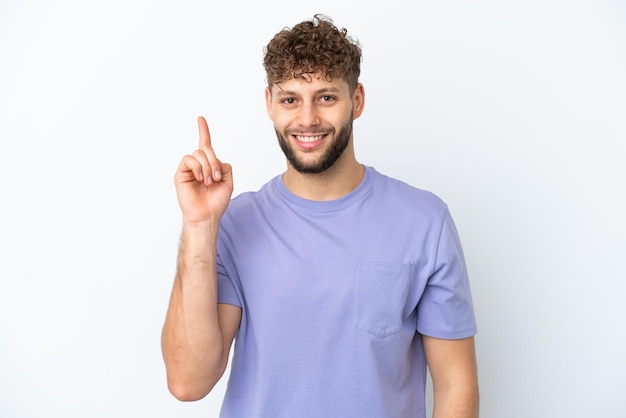 Young handsome caucasian man isolated on white background showing and lifting a finger in sign of the best