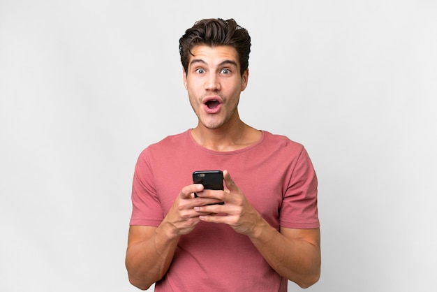 Young handsome caucasian man over isolated white background surprised and sending a message