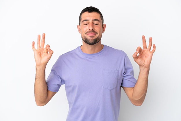 Young handsome caucasian man isolated on white background in zen pose