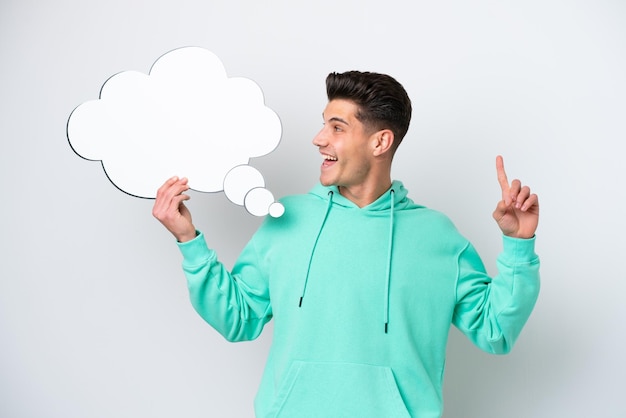 Young handsome caucasian man isolated on white bakcground holding a thinking speech bubble with surprised expression