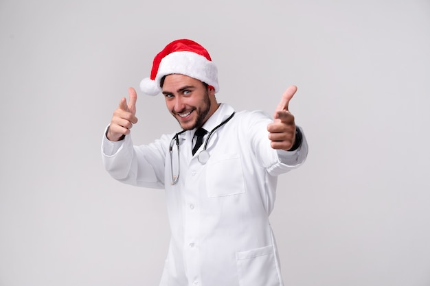 Young handsome doctor in white uniform and Santa Claus hat