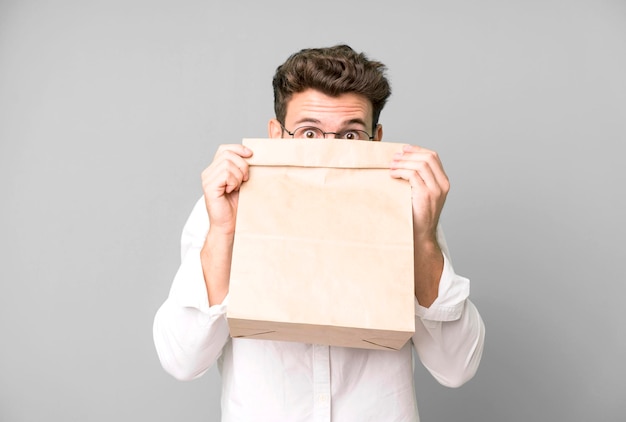 Young handsome employee man with a take away food paper bag