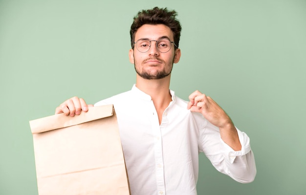 Young handsome employee man with a take away food paper bag