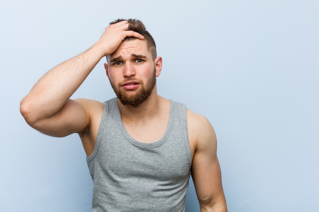 Young handsome fitness man being shocked, he has remembered important meeting.