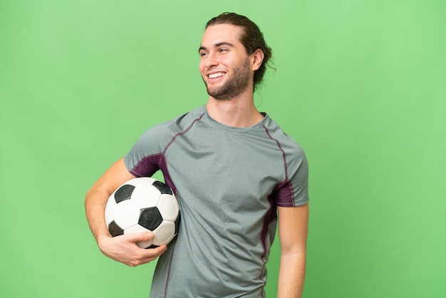 Young handsome football player man over isolated background looking to the side and smiling