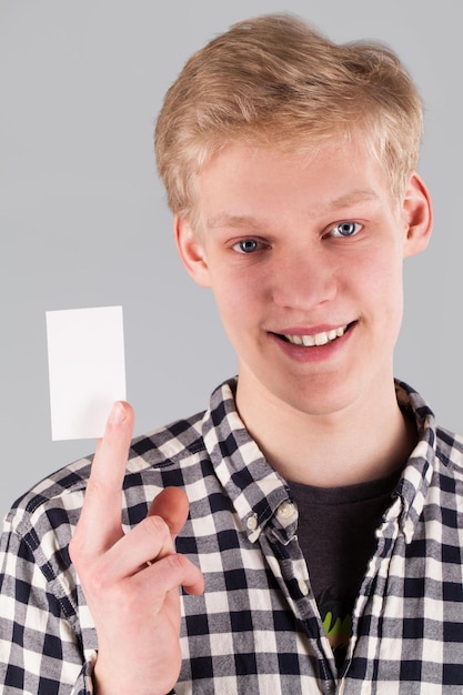 Young handsome guy holding a blank card